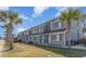 A line of two story townhomes shows a well-maintained facade with blue/gray siding and palm trees at 1881 Colony Dr. # 8-S, Surfside Beach, SC 29575