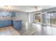 Well lit living room featuring wood look floors, leading to a kitchen with blue cabinets at 1881 Colony Dr. # 8-S, Surfside Beach, SC 29575