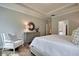 Serene main bedroom with a tray ceiling, wood floors, and a view into the en suite bathroom at 2009 Lone Cypress Dr, Myrtle Beach, SC 29579