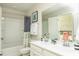 Bright bathroom with double sink vanity, framed mirror, shower-tub combo and decoratively-patterned shower curtain at 2017 Lone Cypress Dr, Myrtle Beach, SC 29579