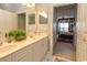 Well-lit bathroom with double sinks, white cabinetry, and an open doorway to the bedroom at 2241 Waterview Dr. # 224, North Myrtle Beach, SC 29582