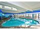 Bright indoor pool area with ocean view, lounge chairs, tables, and blue trim at 2401 S Ocean Blvd. # 854, Myrtle Beach, SC 29577