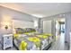 A bedroom featuring a king bed with yellow patterned bedding, a white nightstand and gray walls at 2401 S Ocean Blvd. # 953, Myrtle Beach, SC 29577