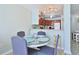 Dining room adjacent to the kitchen featuring a glass table, seating for four, and stylish decor at 2405 S Ocean Blvd. # 304, North Myrtle Beach, SC 29582