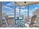 Screened patio featuring an outdoor table and chairs with ocean views under a sunny blue sky in this condo at 2405 S Ocean Blvd. # 304, North Myrtle Beach, SC 29582