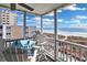 Screened patio with an outdoor table and chairs overlooking ocean views from this condo at 2405 S Ocean Blvd. # 304, North Myrtle Beach, SC 29582