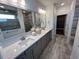 Modern bathroom with a double vanity, large mirrors, gray cabinets, and a walk-in shower at 2534 Watershed Way, North Myrtle Beach, SC 29568