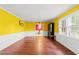 Bright living room with wood-look floors, yellow accent wall, and wainscoting at 2560 Wise Rd., Conway, SC 29526