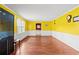 Bright living room with wood-look floors, yellow accent wall, and wainscoting at 2560 Wise Rd., Conway, SC 29526