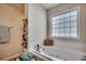 Bright bathroom featuring a jetted soaking tub with tiled backsplash and a privacy window at 305 Aqua Vista Ct., Myrtle Beach, SC 29588