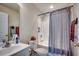 Clean bathroom featuring a white vanity, toilet, and shower/tub combination with a blue shower curtain at 305 Aqua Vista Ct., Myrtle Beach, SC 29588