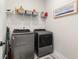 This laundry room includes washer and dryer and additional shelving for storage at 3074 Viceroy Loop, Little River, SC 29566