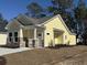 Lovely yellow home with a stone foundation, covered porch, and fresh landscaping at 3135 Tiger Tail Rd., Conway, SC 29526