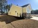 Side view of a yellow home with a stone foundation, showing a well-maintained lawn and landscaping at 3135 Tiger Tail Rd., Conway, SC 29526