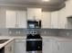 Modern kitchen with white cabinets, gray backsplash, stainless steel appliances, and quartz countertops at 3135 Tiger Tail Rd., Conway, SC 29526