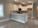 Modern kitchen with white cabinets, gray backsplash, breakfast bar and wood-look floors at 3135 Tiger Tail Rd., Conway, SC 29526