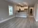 Open floor plan kitchen and living room with gray vinyl floors and modern white cabinets at 3135 Tiger Tail Rd., Conway, SC 29526
