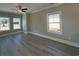 Bright living room with gray vinyl floors, ceiling fan, and large windows offering natural light at 3135 Tiger Tail Rd., Conway, SC 29526