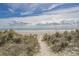 Path to beach access that is flanked by dunes and wild beach grass at 3228 Goldenrain Ln., Little River, SC 29566