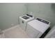 Laundry room with white washer and dryer, shelving, and neutral tile flooring at 354 Glacier Way, Conway, SC 29526