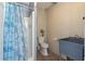 A compact bathroom with a charming blue shower curtain and a practical utility sink at 3615 Sunfish St., Murrells Inlet, SC 29576