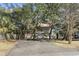 Charming coastal home on stilts, with a red metal roof and mature trees at 3615 Sunfish St., Murrells Inlet, SC 29576