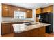 Well-appointed kitchen boasts wood cabinets, granite counters, and a center island with sleek appliances, offering efficiency and style at 3615 Sunfish St., Murrells Inlet, SC 29576