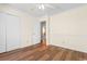 Well-lit bedroom featuring hardwood floors, a ceiling fan, and a closet for convenient storage solutions at 3816 James Pl., Little River, SC 29566