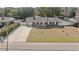 An aerial view of a single-story brick house with a fenced yard and a long concrete driveway at 4048 Sandtrap Ave., Little River, SC 29566