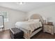 Bedroom with a cushioned headboard, dark wood floors, and a leather ottoman at 4048 Sandtrap Ave., Little River, SC 29566