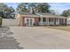 Charming brick home featuring a well-manicured lawn, inviting porch, and convenient driveway with a white privacy fence at 4048 Sandtrap Ave., Little River, SC 29566