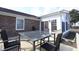 Back patio area featuring a glass table with wicker chairs, and the home with a sunroom at 4339 Dew N. Ct., Myrtle Beach, SC 29579