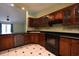 Well-lit kitchen features wood cabinets, black appliances, and black and white patterned tile flooring at 4339 Dew N. Ct., Myrtle Beach, SC 29579