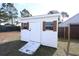 White storage shed with a ramp and shuttered windows, providing extra space for your outdoor equipment at 4339 Dew N. Ct., Myrtle Beach, SC 29579