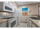 Bright kitchen featuring white appliances, cabinetry and tile flooring at 4494 Little River Inn Ln. # 2301, Little River, SC 29566