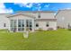 Backyard view featuring screened in porch, manicured lawn and ample space at 560 Pier Ct., Longs, SC 29568