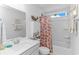 Bright bathroom featuring a combined shower and tub, decorative shower curtain, and ample storage space at 560 Pier Ct., Longs, SC 29568