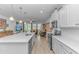 Open-concept kitchen with stainless steel appliances, white cabinets, quartz countertops, and large center island at 560 Pier Ct., Longs, SC 29568