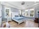 Spacious bedroom with white-painted trim, three windows, ceiling fan and light-colored wood flooring at 587 Starlit Way, Myrtle Beach, SC 29579