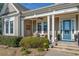 Inviting front porch with comfortable seating, stylish decor, and a bright blue front door at 587 Starlit Way, Myrtle Beach, SC 29579