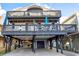 Exterior view of coastal home with a covered parking area and multiple decks with seating at 6001-0917 S Ocean Blvd., Myrtle Beach, SC 29575