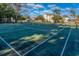 Wide shot of green tennis court with white lines surrounded by lush trees and apartment buildings at 601 Hillside Dr. N # 3736, North Myrtle Beach, SC 29582