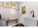 Bright laundry room featuring a utility sink, open shelving, bench, and door to the backyard at 616 36Th Ave. S, North Myrtle Beach, SC 29582