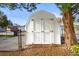 Exterior view of the white barn-style shed, fenced yard, and mature tree at 616 36Th Ave. S, North Myrtle Beach, SC 29582