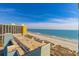 Expansive view of the beach and ocean from a high-rise condo with balcony access and a clear blue sky at 6804 N Ocean Blvd. # 1211, Myrtle Beach, SC 29572