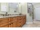 Bathroom with double vanity, granite countertop, wooden cabinets, and a glass-enclosed tiled shower at 704 Compass Pointe Dr, North Myrtle Beach, SC 29582