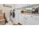 Bright laundry room with white cabinetry and modern, front-loading washer and dryer at 704 Compass Pointe Dr, North Myrtle Beach, SC 29582