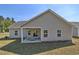 Exterior view of the back of the house with a covered patio, and a green lawn at 7059 Shady Grove Rd., Conway, SC 29527