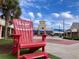 Tanger Outlets shopping center view with an oversized red Adirondack chair in the foreground at 7059 Shady Grove Rd., Conway, SC 29527