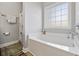 Bright bathroom featuring a white tub, a window, and a shower with decorative curtain at 825 Payne Ct., Conway, SC 29526